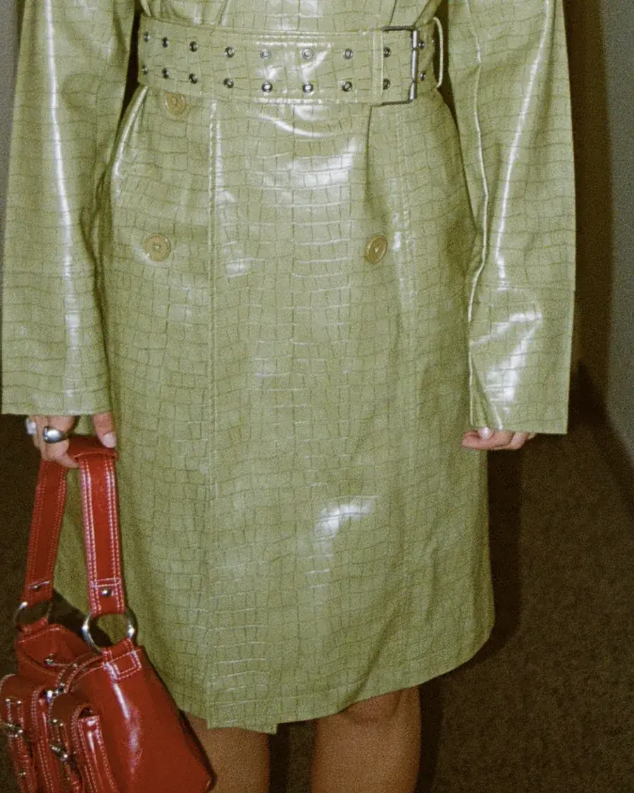 Trench verde croco con bolso rojo de charol